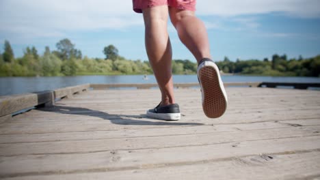 Walking-across-a-wooden-dock-on-a-lake-in-the-summer