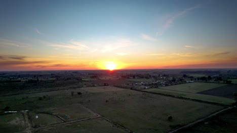 Sonnenuntergang-Auf-Dem-Land-Auf-Feldern-Und-Im-Dorf,-Panorama-Verkleinerung-Per-Drohne