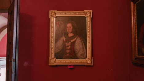 Vintage-portrait-of-a-noble-figure,-elegantly-framed-and-mounted-on-a-rich-red-wall-within-Trakošćan-Castle,-Croatia