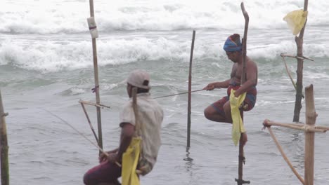 Zwei-Fischer-Fangen-Fische-Mit-Der-Traditionellen-Sri-lankischen-Fangmethode,-Dem-Sogenannten-Stelzenfischen.