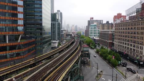 Aerial-Establishing-Shot-of-Subway-Train-Stopped-at-Elevated-Station-Picking-Up-Passengers-on-Foggy-Day-in-New-York-City
