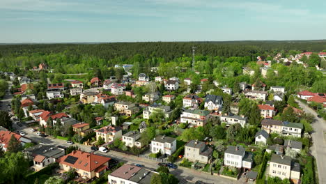 Una-Vista-Aérea-De-Una-Zona-Residencial-En-Olsztyn,-Que-Muestra-Casas-Con-Techos-Rojos-Y-Grises-Rodeadas-De-árboles-Y-Vegetación-Verdes.