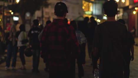 People-walk-the-popular-and-crowded-streets,-sidewalks,-and-alleyways-of-Braga-district-at-night