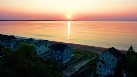 Sunset-Colors-Reflect-off-Ocean-Waves-Overlooking-Beach-Houses
