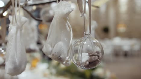 Slow-dolly-shot-of-rocks-in-white-bags-and-baubles-at-a-wedding