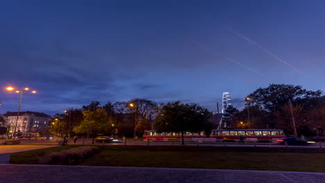 Huge-Christmas-illuminated-wheel-for-people-with-beautiful-view-of-Moravian-Square-in-Brno-with-public-traffic-cars-and-people-walking-around-during-sunset-from-day-to-night-time-before-light-turn-on