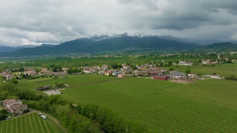 City-surrounding-the-Dolomites-Mountains-in-Italy-wintertime-snow-drone-4k