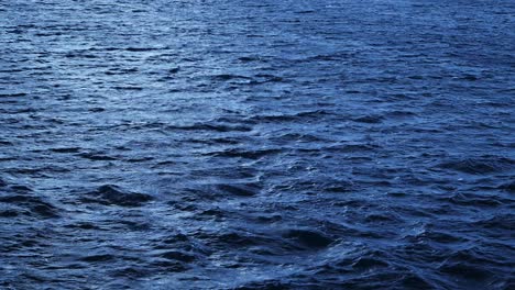 Blue-Ocean-and-Sea-Water-Close-Up,-Ripples-of-Choppy-Ocean,-Dark-Minimal-Background-with-Copy-Space