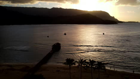 Zoom-Out-Aerial-From-Hanalei-Pier-at-Sunset-with-Boats
