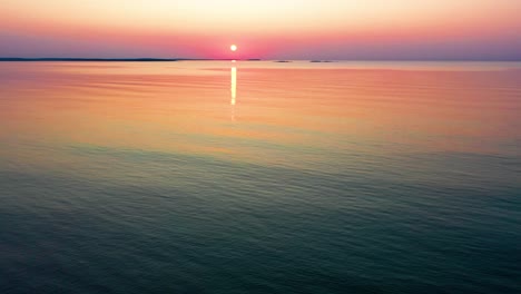 Aerial-Drone-View-of-Colorful-Beach-Sunrise-in-Saco,-Maine-with-Bright-Colors-Reflecting-off-Calm-Rippling-Ocean-Waves-Along-the-New-England-Atlantic-Coastline