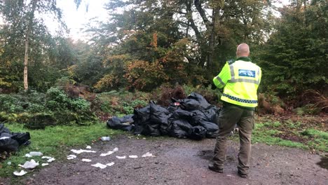 Volcar-Las-Propinas-En-El-Bosque-De-Epping,-Inglaterra,-El-Oficial-De-Policía-Toma-Una-Fotografía-Sobre-El-Montón-De-Basura-Arrojada-En-El-Aparcamiento