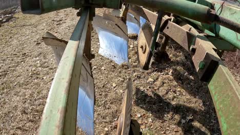 Close-up-on-disc-and-chisel-of-plow-as-farmer-moves-plow-to-the-field