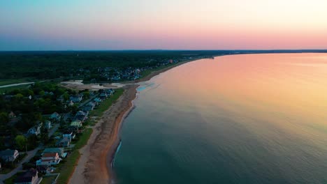 Luftaufnahme-Von-Wunderschönen-Strandhäusern-Und-Sonnenuntergang-über-Ferienhäusern-In-Maine-Und-Farben,-Die-Sich-In-Den-Meereswellen-Entlang-Der-Atlantikküste-Von-Neuengland-Spiegeln