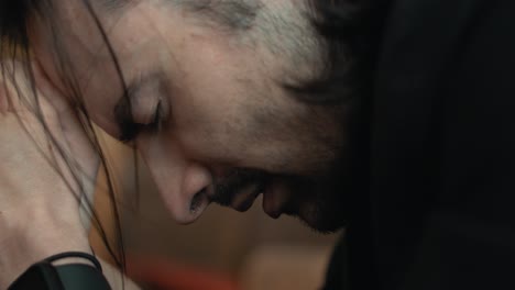 Closeup-of-a-young-man-in-black-suit-praying-in-church-in-cinematic-slow-motion