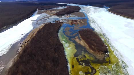 A-large-mountain-river-thaws-from-ice-in-a-sunny-spring-from-a-bird's-eye-view