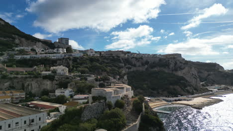 A-beautiful-4K-drone-shot-orbiting-around-Parson's-lodge-with-the-bay-of-Gibraltar-included-and-the-rock-of-Gibraltar-on-a-partly-cloudy-day