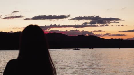 Silhouette-Des-Modells-Beobachten-Wunderschönen-Sonnenuntergang-über-Dem-See