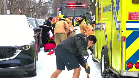 Feuerwehrleute-Helfen-Einer-Person-Auf-Verschneiter-Straße,-Notfallreaktion-In-Montreal