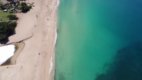 Luftaufnahmen-Entlang-Der-Nordküste-Der-Insel-Oahu,-Hawaii,-Zeigen-Weiße-Sandstrände,-Die-Das-Klare,-Türkisfarbene-Wasser-Des-Pazifischen-Ozeans-Von-Den-üppigen,-Mit-Regenwald-Bedeckten-Bergen-Trennen