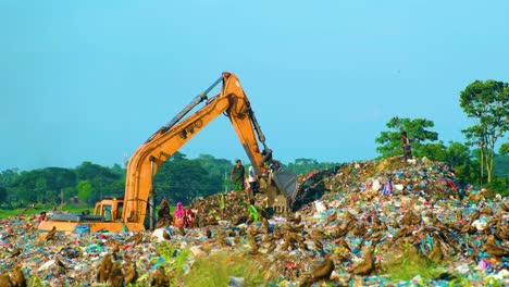 Excavator-At-Landfill-Site-in-Dhaka,-Bangladesh,-Eagle-Birds-Flying--Wide-Shot