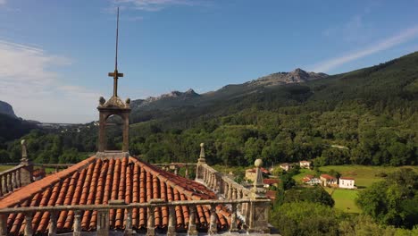 descent-flight-with-a-drone-in-the-church-of-San-Vicente-16th-17th-centuries-seeing-the-wonderful-rural-environment-appreciating-the-head-of-the-bell-tower-in-Rio-Frio-Cantabria-Spain