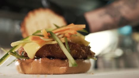 Preparation-of-cheeseburger-with-vegetables-and-bread-on-top-with-wooden-stick