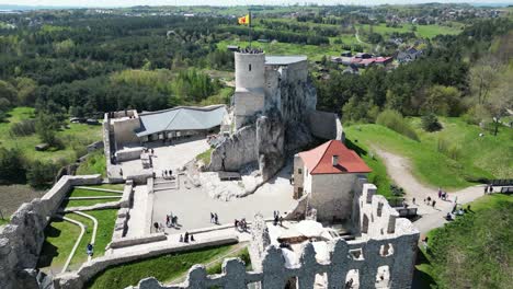 Castillo-Medieval-Sobre-La-Roca-Con-Una-Torre,-Murallas-Y-Un-Patio-Durante-Un-Hermoso-Día-De-Verano-Rodeado-De-Exuberante-Vegetación,-Hierba-Y-árboles