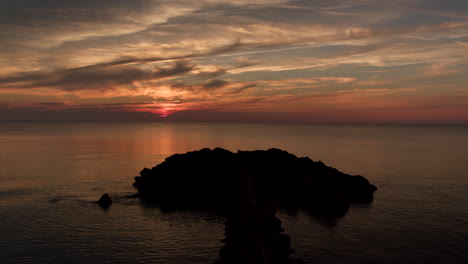 Zoom-Away-From-Rocks-During-Dark-Cinematic-Sunset-Over-New-Jersey-Bay