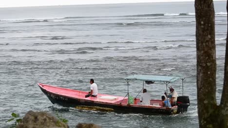 Four-locals-riding-along-the-coast-in-a-small-fisherman-motorboat