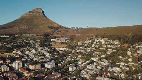 Drone-flying-over-an-urban-neighborhood-with-Lion's-Head-Mountain-in-the-background-in-Cape-Town-South-Africa