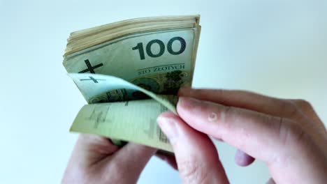 El-Hombre-Cuenta-Billetes-De-100-Zlotys-En-El-Fondo.