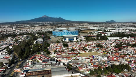 Vista-Aérea-Que-Se-Eleva-Hacia-El-Estadio-Cuauhtémoc-En-La-Soleada-Puebla,-México