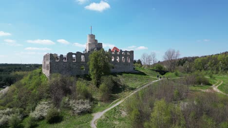 Castillo-Medieval-De-Rabsztyn-Con-Torreta,-Murallas-Y-Patio-Durante-Un-Hermoso-Día-De-Verano-Rodeado-De-Exuberante-Vegetación,-Hierba-Y-árboles-Bajo-Un-Cielo-Azul-Claro