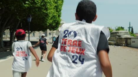 Toma-De-Seguimiento-En-Primera-Persona-De-Niños-Corriendo-Una-Carrera-En-El-Centro-De-Montpellier