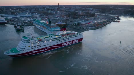 Aerial-view-of-Viking-Line-cruise-ship-Amorella-moving-backwards-when-arriving-to-port-during-lowlight-morning-sunrise