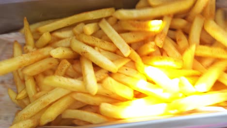 A-chief-put-salt-on-french-fries,-close-up-shot,-insert-shot