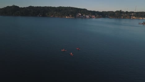 Aerial-drone-shot-of-friends-doing-paddle-boarding-at-the-lake