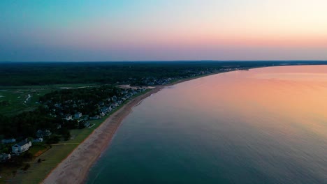 Aerial-Drone-View-of-Sunrise-over-Beach-Houses-with-Colors-Reflecting-off-Ocean-Waves-and-Vacation-Homes-Along-the-New-England-Atlantic-Coastline