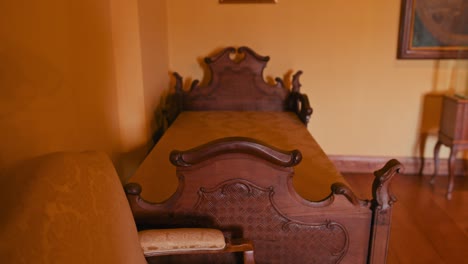 Bed-in-the-Rococo-Room-of-Trakošćan-Castle,-Croatia,-showcasing-intricate-woodwork