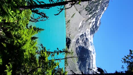 Das-Ikonische-Türkisfarbene-Wasser-In-Den-Joffre-Seen---Langsames-Gehen-Offenbart-Sich-Durch-Die-Bäume,-Während-Sich-Der-Wanderweg-Dem-Eiskalten-Gletscherschmelzwasser-Nähert