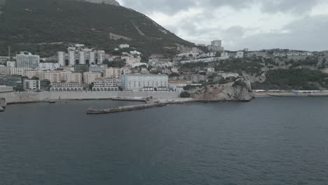 Una-Toma-De-4k-Al-Atardecer-En-Un-Día-Oscuro-Y-Nublado,-Desde-Un-Dron-Que-Volaba-Desde-La-Bahía-De-Gibraltar-Hacia-La-Bahía-De-Rosia-En-Gibraltar