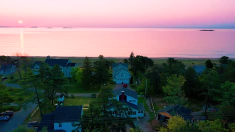 Wunderschöne-Strandhäuser-Und-Sonnenaufgang-über-Ferienhäusern-In-Maine-Und-Farben,-Die-Sich-In-Den-Meereswellen-Entlang-Der-Atlantikküste-Von-Neuengland-Spiegeln