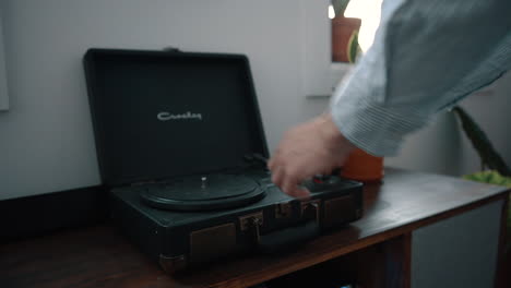 Wide-shot-of-hands-open-and-turn-on-a-turntable