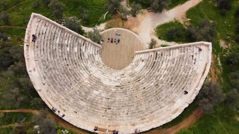 Fly-Up-Above-1st-Century-BCE-Ancient-Amphitheater-Overlooking-the-Mediterranean-Sea-Towards-Greek-Islands,-Antiphellos-Theatre-with-Coastal-View,-in-Kas,-Turkey:-Turkish-South-Coast