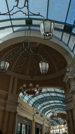 Vertical-Video,-People-and-Glass-Ceiling-in-Hallway-of-Bellagio-Las-Vegas-Casino-Hotel-Resort