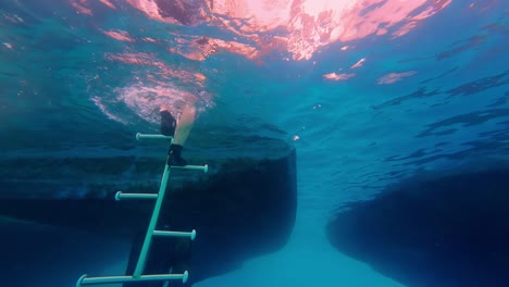 Füße-Eines-Tauchers-Steigen-Unter-Wasser-Auf-Eine-Treppe-Und-Enthüllen-Eine-Person,-Die-Aus-Dem-Meer-Geht