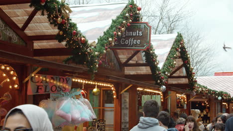 panning-across-shot-to-reveal-people-walking-past-the-christmas-market-stalls-in-slowmotion