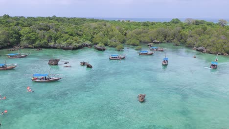 Drone-reveal-tourists-snorkeling-in-vibrant-teal-Kwale-Island-lagoon-in-Zanzibar