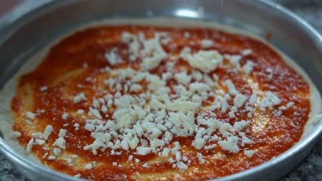 A-chief-puts-Mozzarella-on-an-Italian-pizza,-close-up-shot,-insert-shot