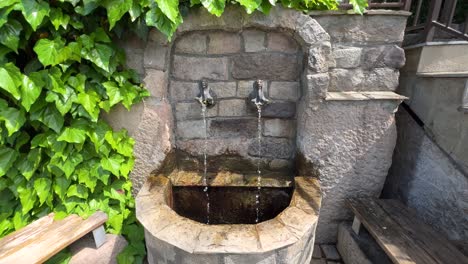 Ein-Wunderschöner-Steinmauer-Springbrunnen,-überwuchert-Mit-Efeu